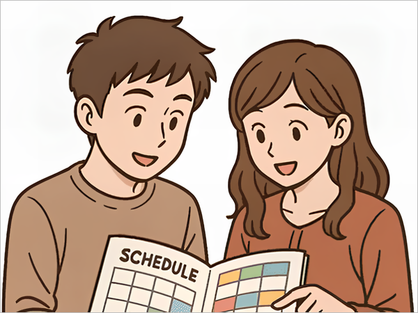 スケジュール帳を一緒に見ている笑顔の男女